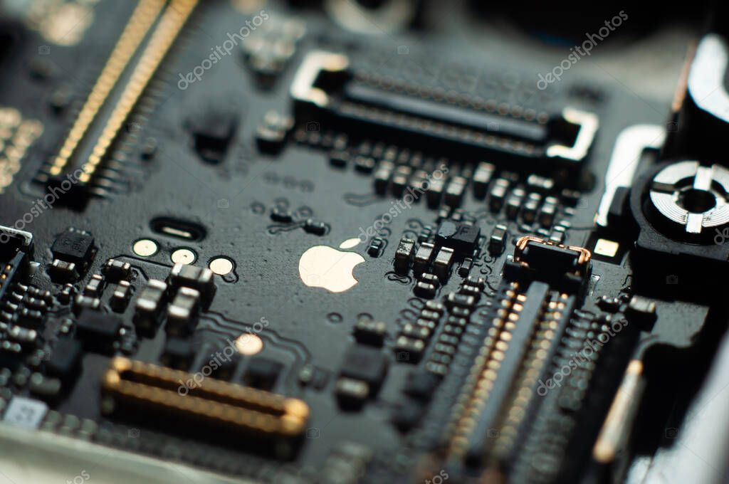 Kiev, Ukraine - May 6, 2020: Close-up image of the central board of the apple iphone se. Golden Apple. Service repair.