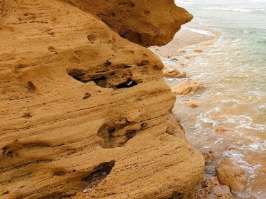 Kahverengi sahildeki kayalara yakından bak. Rüzgârlar, su işaretleri, deniz dalgaları...