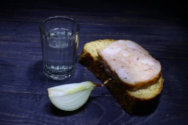 Bir bardak votka, sosisli ekmek ve soğanlı.