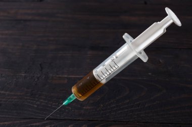 Tahta bir masada uyuşturucu şırıngası.