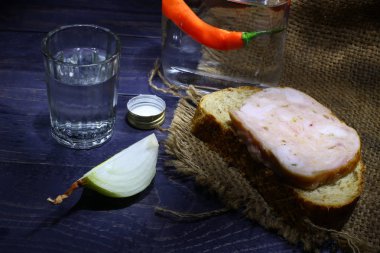 Bir bardak votka, sosisli ekmek ve soğanlı.