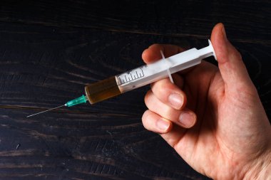 Elinde uyuşturucu olan bir şırınga.