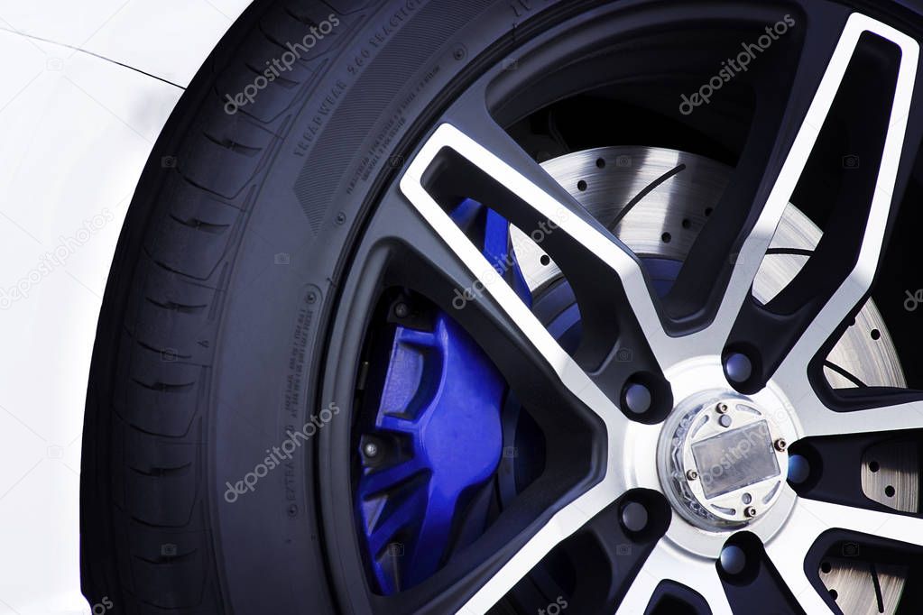 Racing rim wheel with disc brake and blue caliper.