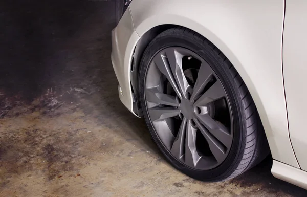 Dirty wheel in white luxury car. — Stock Photo, Image