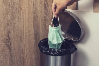 Tek kullanımlık tıbbi maskeler, bulaşıcı atık kutusuna bırakılmak, Corona virüsünün önlenmesi, Covid-19 konsepti..