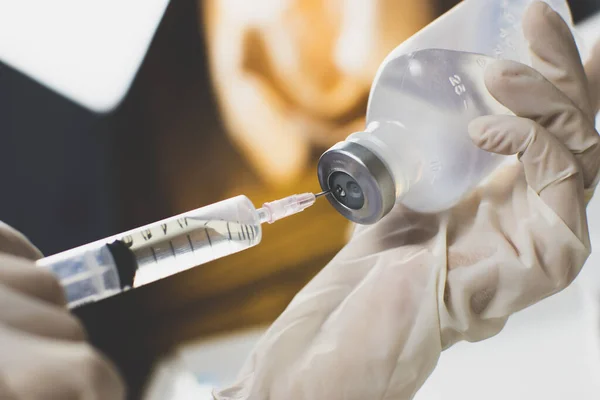 Anestezi uzmanları şırıngayı normal tuz çözeltisine (NSS), Coronavirus tedavi konseptine, Covid-19.