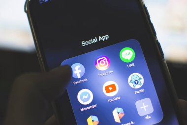 Rayong, Tayland - 2 Mayıs 2020: Geceleri Huawei y9 2019 telefon kullanan bir adamın eli Facebook, Instagram, Line, Messenger, Youtube gibi sosyal medya simgeleriyle.