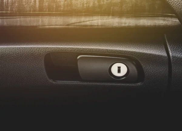 Keyhole for locking of car glove box compartment in a luxury car.