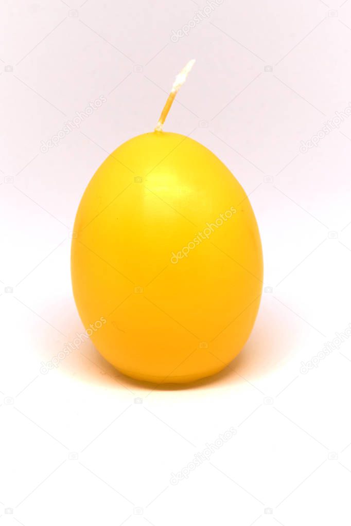 Easter candle in egg form on a white background