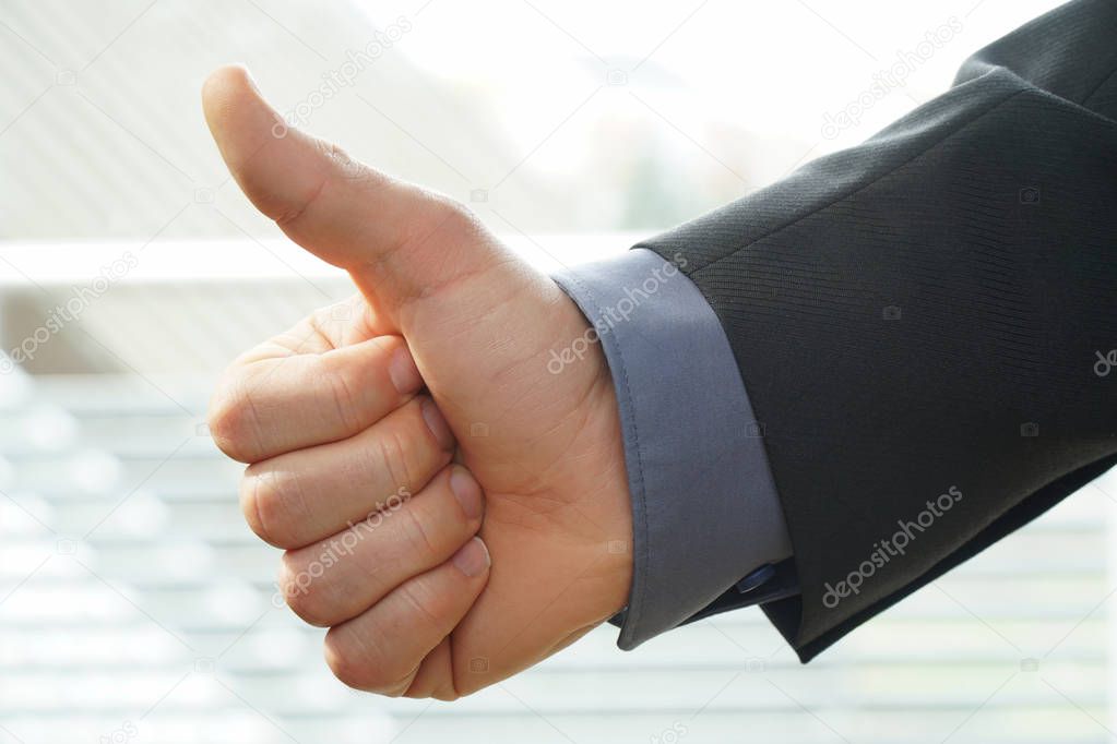 businessman shows thumps up sign for his approval