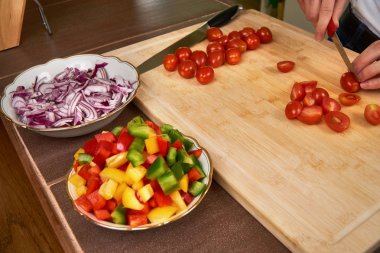 Öğle yemeği için bir yemek hazırlama taze domates mutfakta kesme eller mans. Yan görünüm.