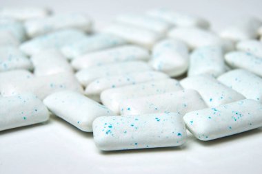 Chewing gum spilled out on white background with low depth of field - macro shot. clipart