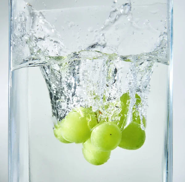Świeże winogrona zielone rozpryskiwania do wody. — Zdjęcie stockowe
