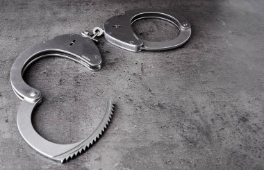 Polis kelepçe kaba gri arka plan üzerinde kopya alanı ile açıldı.
