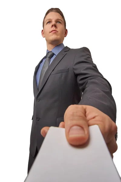Isolated young attractive successful seriously businessman hands over a business card. Low angle shot with copy space. — Stock Photo, Image