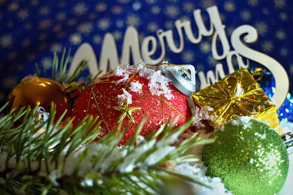 Weihnachtsschmuck im Schnee liegend mit Zeichen frohe Weihnachten. — Stockfoto