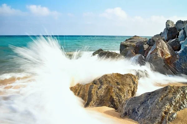 Ondas do mar atingindo a praia rochosa em Malgrat de Mar, Espanha . — Fotografia de Stock