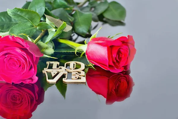 Червоні троянди з відображенням в дзеркало і напис: любов. Валентина теми. Романтичні моменти. — стокове фото