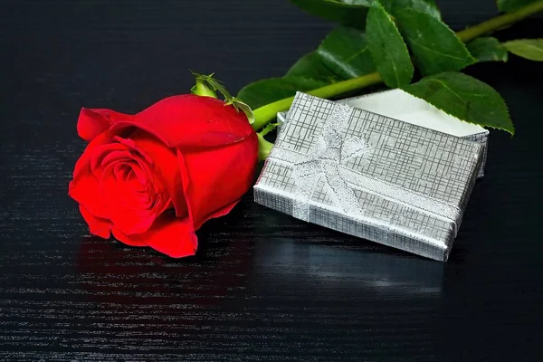 Червона троянда з несподіванкою в коробці на розкішному дерев'яному столі. Для закоханих. Роза і подарунок на дерев'яному столі . — стокове фото