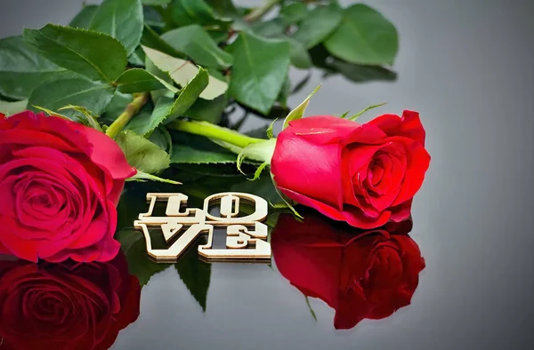 Roses rouges avec reflet dans le miroir et l'inscription : AMOUR. Thème de la Saint Valentin. Moments romantiques . — Photo