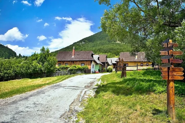 Vlkolinec - Bergdorf mit einer typischen Volksarchitektur mitteleuropäischen Typs. typischer Eingang zu einer Siedlung mit Holzstatuen. — Stockfoto