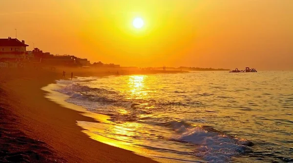 Die Strahlen der aufgehenden Sonne über dem Mittelmeer mit schlammigem Hintergrund in malgrat de mar, Spanien. — Stockfoto