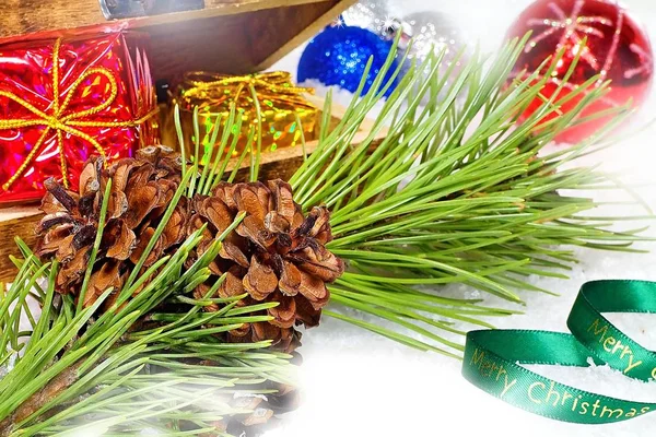 Weihnachtspostkarte. schöne bunte Weihnachtsgrüße mit Tannenzapfen auf einem Zweig mit Weihnachtsdekoration. — Stockfoto