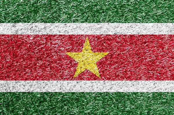 Suriname bandeira no fundo da grama textura — Fotografia de Stock