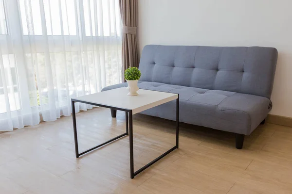 リビングルームでテーブルと小さな植物と快適なソファ — ストック写真