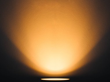 Lamba duvarda sıcak ışıkla parlıyor. Ilık ışıklandırma.