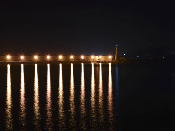Светильники на плотине в порту ночью — стоковое фото