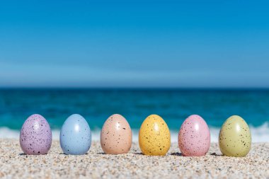 Renkli Paskalya yumurtası güneşli gün sahilde. Paskalya kavramı.