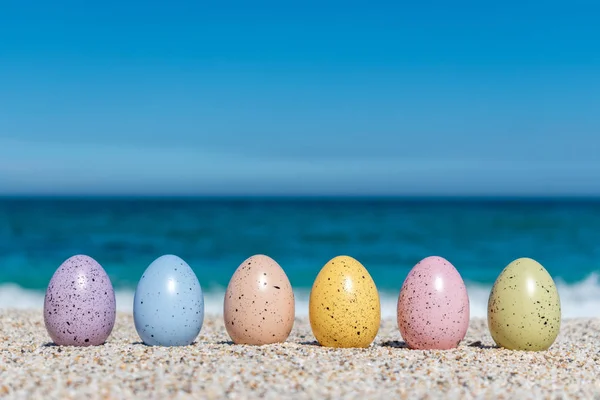 Œufs de Pâques colorés sur la plage par temps ensoleillé. Concept de Pâques . — Photo