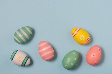 Mavi arka plan üzerinde renkli Paskalya yumurtaları. Paskalya en az kavramı.