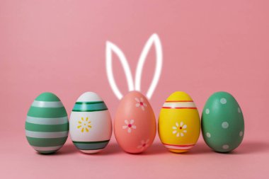 Renkli Paskalya yumurtaları ile çizilmiş tavşan kulakları el.