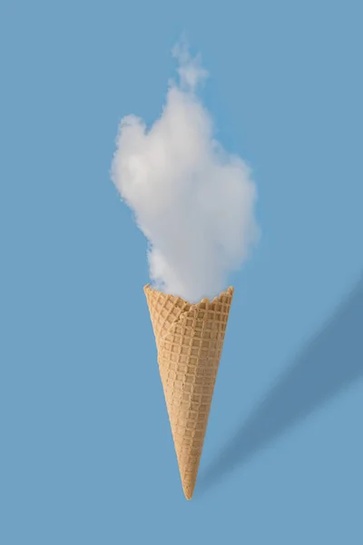 Kužel zmrzliny a bílý oblak na pastelově modré pozadí. — Stock fotografie