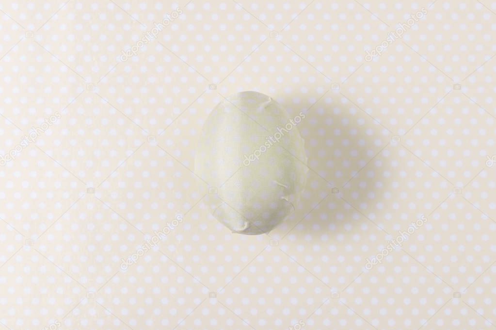 Easter egg decorated with yellow paper napkin. Minimal concept.