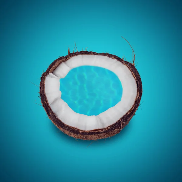 Noix de coco en gros plan avec de l'eau de piscine sur fond bleu . — Photo