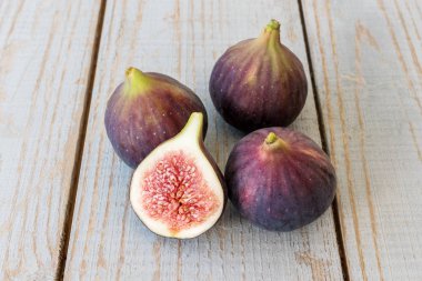 Yarım bir bahçe masa üstünde bütün incir ve bir incir dilimlenmiş.