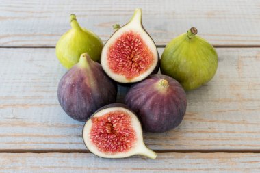 Yarım bir bahçe masa üstünde bütün incir ve bir incir dilimlenmiş.