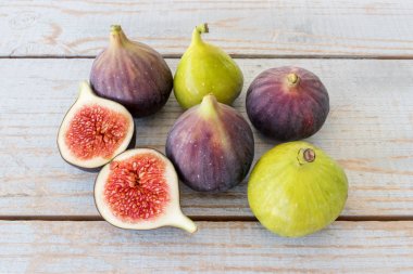 Yarım bir bahçe masa üstünde bütün incir ve bir incir dilimlenmiş.