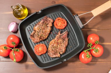 Koyu arka plan üzerinde domates ızgara tava üzerinde ızgara biftek 