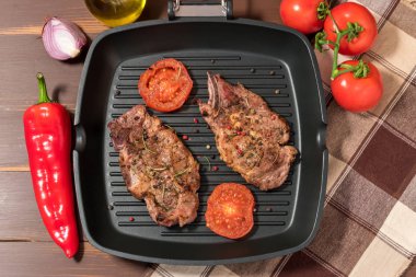 Koyu arka plan üzerinde domates ızgara tava üzerinde ızgara biftek 