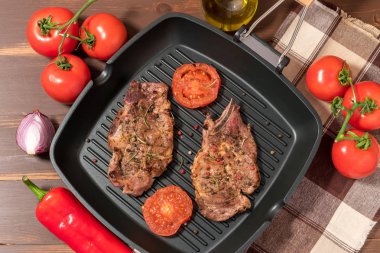 Koyu arka plan üzerinde domates ızgara tava üzerinde ızgara biftek 