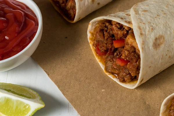 Gustoso burrito fatto in casa con verdure e manzo su carta . — Foto Stock