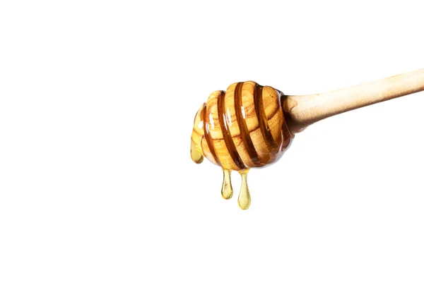 Μέλι που στάζει από την κουτάλα μελιού σε λευκό φόντο. — Φωτογραφία Αρχείου