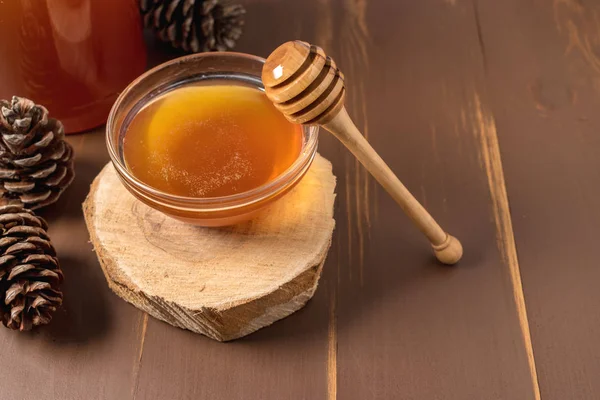 Miód z łyżki drewniane miód w słoiku na drewnianym stole — Zdjęcie stockowe