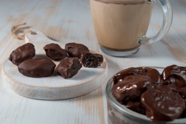 Çikolata ahşap arka plan üzerinde kuru erik.