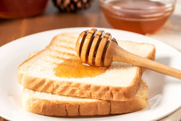 Μέλι με ραβδί ρίχνει πάνω από ψωμί τοστ — Φωτογραφία Αρχείου