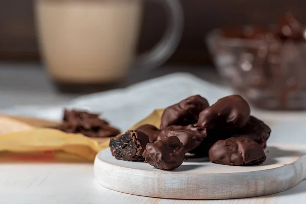 Prunes in chocolate on wooden background. — Stock Photo, Image